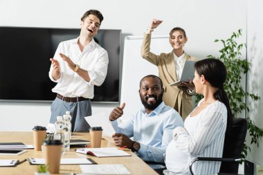 happy business people celebrating triumph in conference room clipart