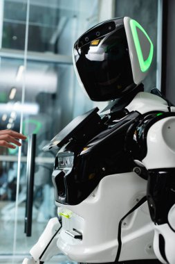 Ofiste kadın eli, insansı robotun yanında.