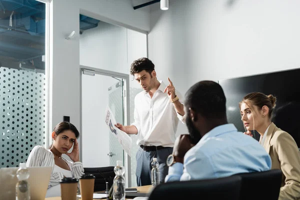 Empresario Con Periódico Mostrando Gesto Idea Cerca Compañeros Trabajo Multiétnicos —  Fotos de Stock