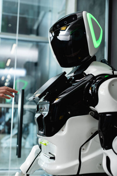 cropped view of female hand near humanoid robot in office