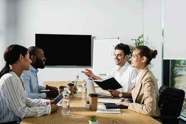 Empresário Alegre Com Caderno Apontando Com Mão Enquanto Conversa Com — Fotografia de Stock