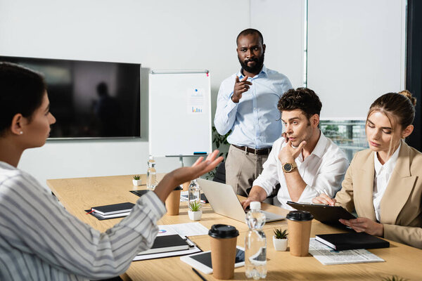 вдумчивый африканский американский бизнесмен, указывая пальцем во время встречи с коллегами