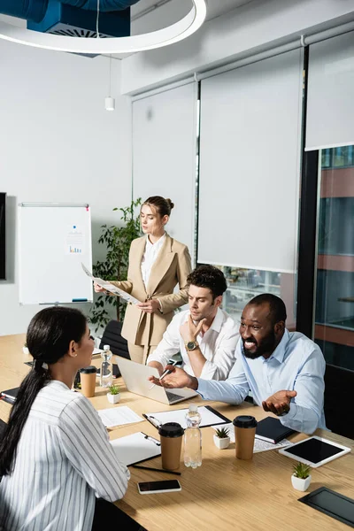 Sonriente Hombre Negocios Afroamericano Haciendo Gestos Durante Reunión Con Colegas — Foto de Stock