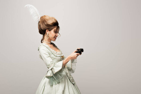 КИЕВ, УКРАИНА - 22 апреля 2021 года: веселая женщина в элегантном стиле ретро игры изолированы на сером