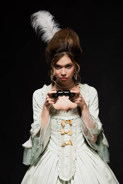 КИЕВ, УКРАИНА - 22 апреля 2021 года: концентрированная женщина в винтажном наряде игры изолированы на черном