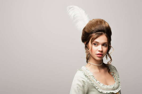 charming woman with retro hairstyle looking away isolated on grey