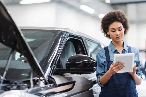 Joven Afroamericano Mecánico Utilizando Tableta Digital Cerca Coche Servicio Reparación —  Fotos de Stock