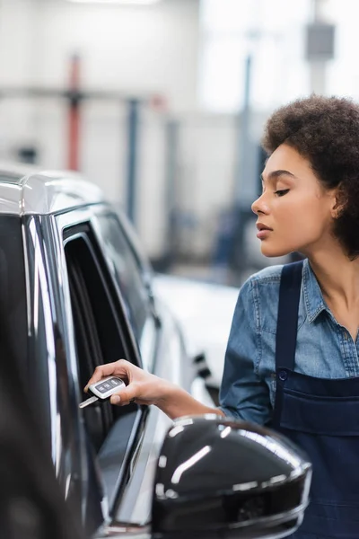 Jovem Afro Americano Mecânico Macacão Segurando Chave Perto Carro Garagem — Fotografia de Stock