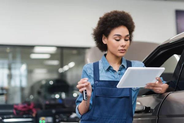 Joven Afroamericano Mecánico Celebración Tableta Digital Llave Del Coche Garaje — Foto de Stock