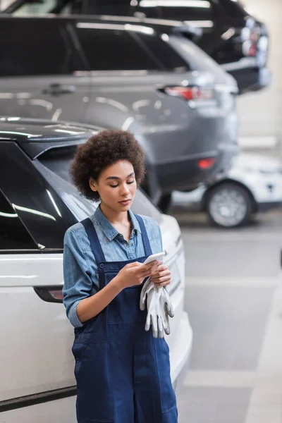 Joven Afroamericano Mecánico Overoles Escribiendo Smartphone Garaje — Foto de Stock