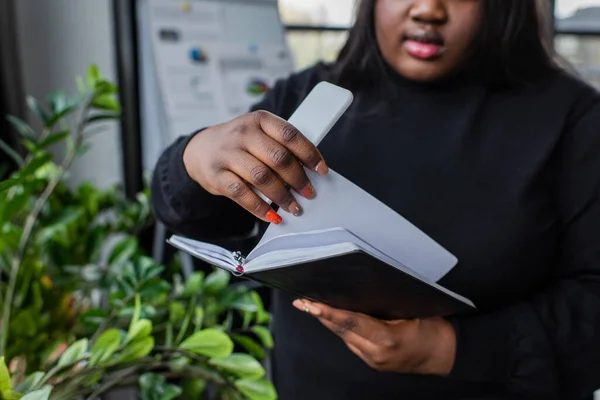 Vista Cortada Africano Americano Size Mulher Segurando Notebook Smartphone Escritório — Fotografia de Stock