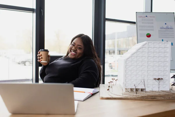 Feliz Africano Americano Más Tamaño Ingeniero Sosteniendo Taza Papel Mientras — Foto de Stock