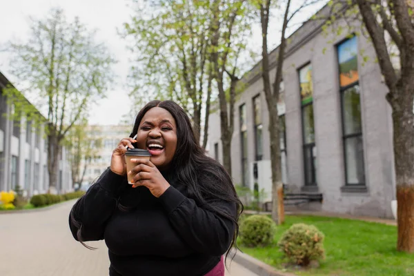 Alegre Afro Americano Size Mulher Segurando Café Para Falar Smartphone — Fotografia de Stock