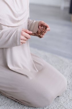 Evinde diz çöküp dua eden müslüman kadın görüntüsü.