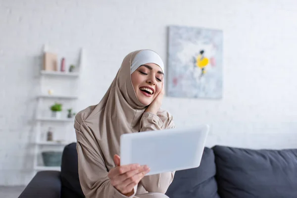 Mujer Musulmana Emocionada Riendo Cerca Tableta Digital Casa — Foto de Stock