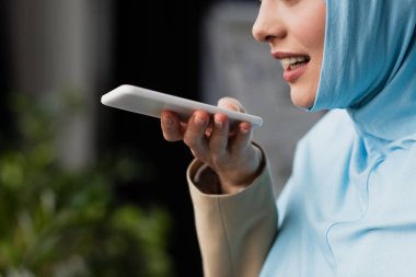 Müslüman iş kadınının cep telefonundan sesli mesaj göndermesinin kısmi görüntüsü