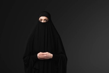 Siyah Niqab ve maya 'lı Arap kadın siyah kameraya bakıyor.