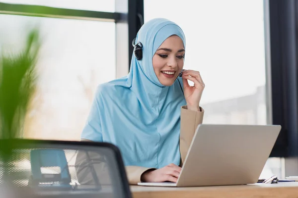 Çağrı Merkezinde Çalışırken Dizüstü Bilgisayar Kullanan Gülümseyen Müslüman Kadın — Stok fotoğraf