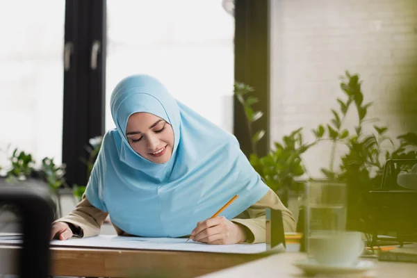 Glimlachende Arabisch Ingenieur Hijab Tekening Blauwdruk Wazig Voorgrond — Stockfoto