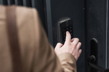 cropped view of man pressing button on intercom keypad  clipart