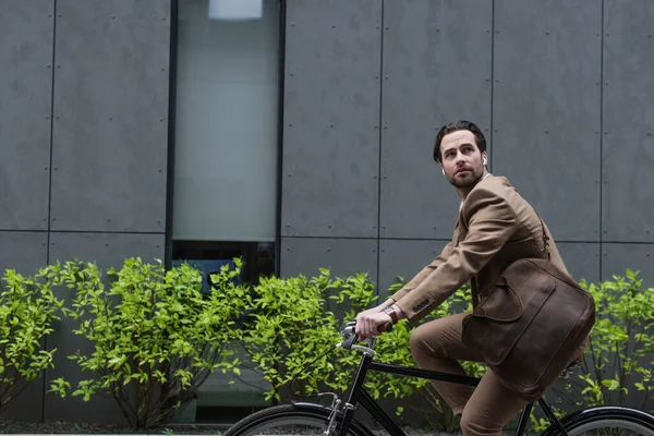 Jeune Homme Affaires Dans Les Écouteurs Équitation Vélo Près Construction — Photo