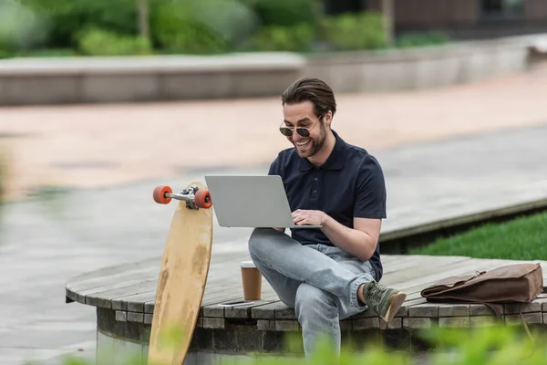 Happy Man Sunglasses Polo Shirt Using Laptop Smartphone Paper Cup — Stock Photo, Image