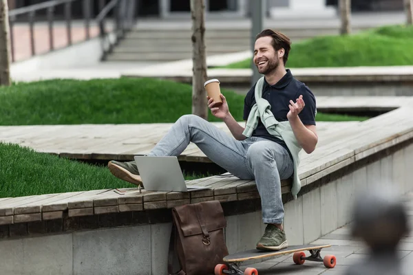 Hombre Alegre Polo Sudadera Sosteniendo Taza Papel Riendo Mientras Sienta — Foto de Stock