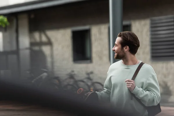 Tişörtlü Mutlu Sakallı Adam Dışarıda Uzun Tahta Deri Sırt Çantası — Stok fotoğraf