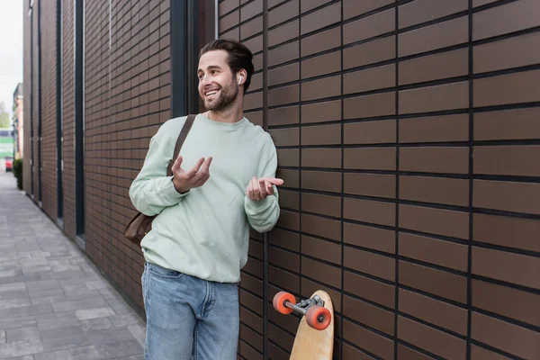 Homem Feliz Camisola Fones Ouvido Sem Fio Falando Gesticulando Fora — Fotografia de Stock