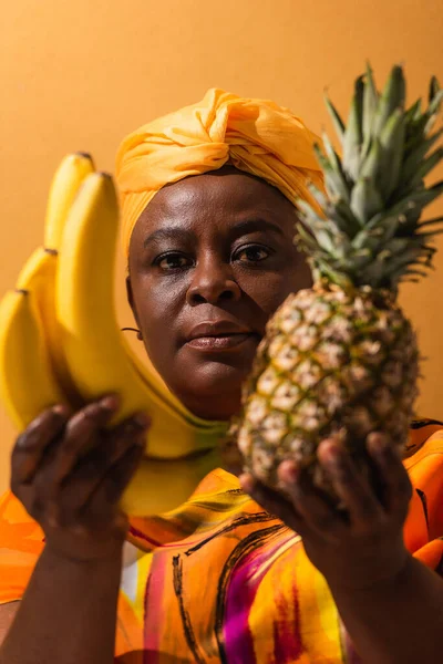 African American Woman Yellow Turban Colorful Dress Holding Pineapple Bananas — Stock Photo, Image