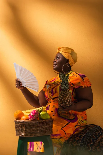 Африканская Женщина Среднего Возраста Сидящая Рядом Фруктами Держащая Ананас Веер — стоковое фото