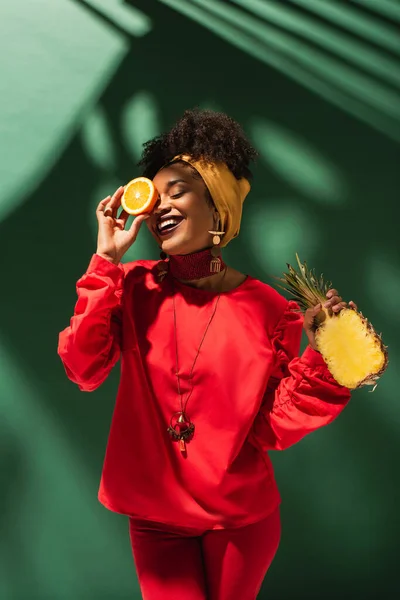 Sonriente Joven Afroamericana Mujer Sosteniendo Medio Corte Naranja Piña Verde — Foto de Stock