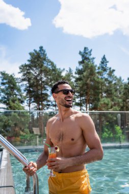 Bilardo merdiveninde kokteyl içerken gözlerini kaçıran neşeli bir Arap.
