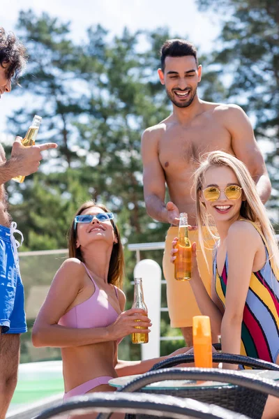 Smiling Woman Swimsuit Holding Beer Multiethnic Friends Sunscreen Outdoors — Stock Photo, Image