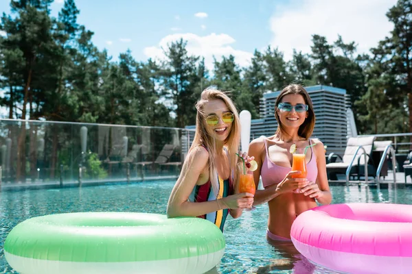 Fröhliche Frauen Halten Cocktails Der Nähe Von Schwimmringen Pool — Stockfoto