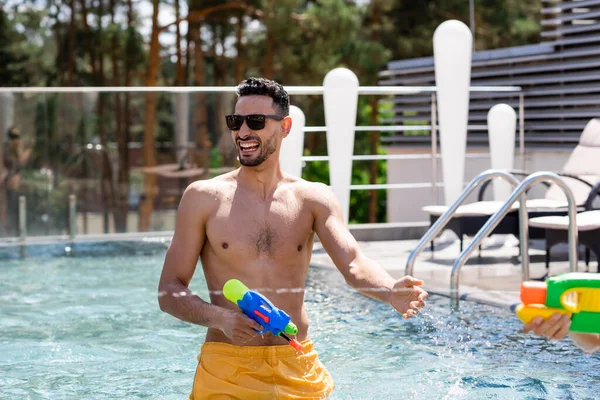 Alegre Árabe Homem Segurando Pistola Água Piscina — Fotografia de Stock