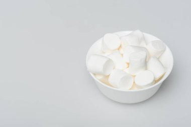 soft and sweet marshmallows in bowl on grey clipart