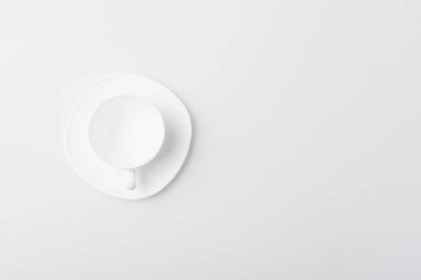 Boş fincan ve fincan tabağının beyaz üzerine izole edilmiş üst görünümü