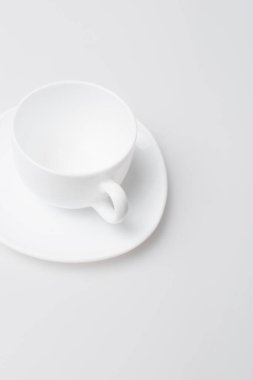 Boş fincan ve fincan tabağının beyaz üzerine izole edilmiş yüksek açılı görünümü