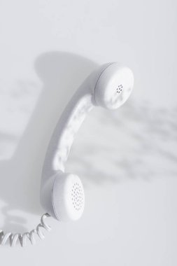 top view of shadows near retro handset on white  clipart