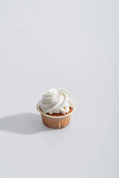 Schatten Der Nähe Von Leckeren Cupcake Mit Sahnehäubchen Auf Weiß — Stockfoto