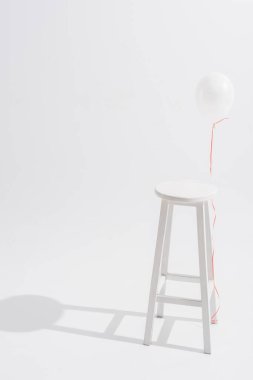 balloon near high wooden stool on white background clipart