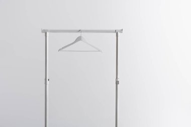 white hanger on garment rack isolated on grey clipart