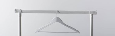white hanger on garment rack isolated on grey, banner clipart