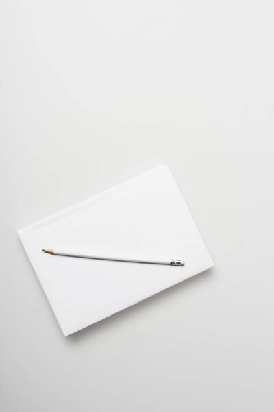 top view of notepad in hardcover with pencil isolated on white 
