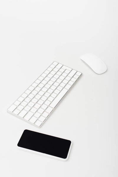 smartphone with blank screen near computer mouse and keyboard isolated on white 