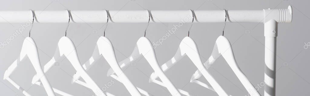 collection of white hangers on clothes rack isolated on grey, banner