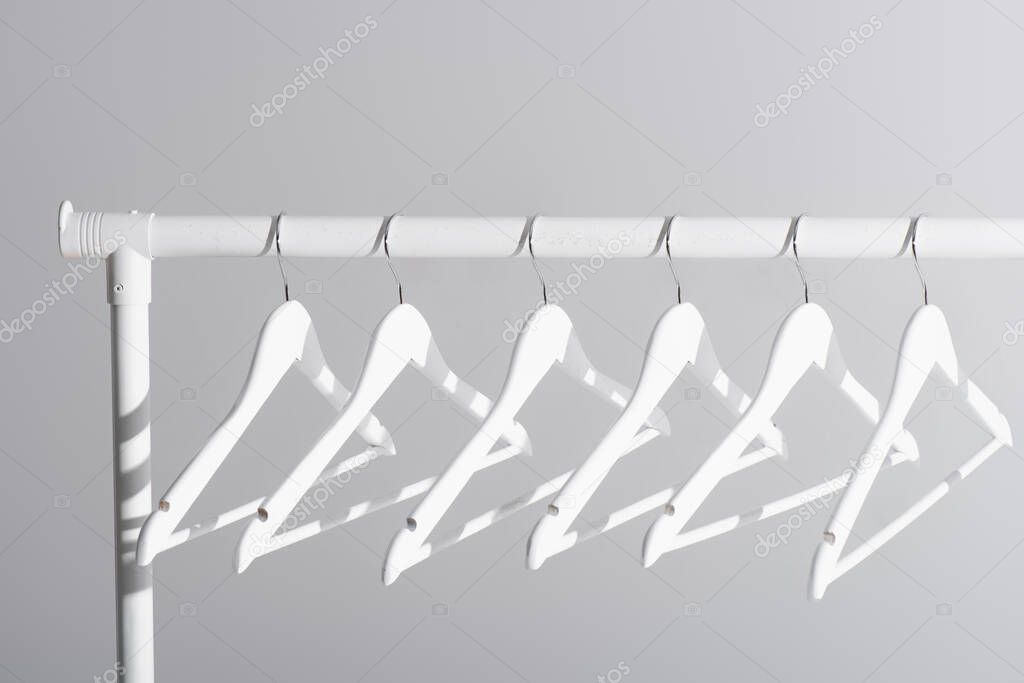 collection of white hangers on clothes rack isolated on grey