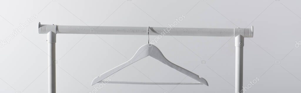 white hanger on garment rack isolated on grey, banner