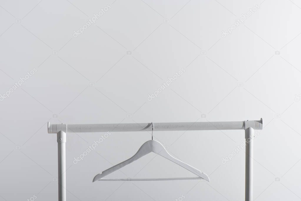 single white hanger on garment rack isolated on grey